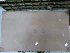 A large travelling trunk, a trouser press, a mirror,