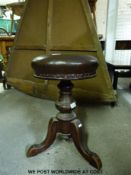 A 19thC leather and mahogany piano or music stool with adjustable revolving height