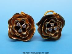 A pair of 18ct gold earrings in the form of flowers set with diamonds to the centre