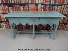 A painted hall table or dresser with three drawers raised on turned legs and stretchers (H77 x W153