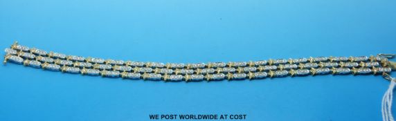 An 18ct gold bicoloured bracelet set with diamonds in a star and oval design