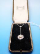 An 18ct gold and platinum necklace set with a central pearl surrounded by round brilliant cut