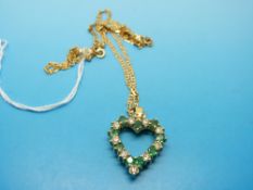 An 18ct gold pendant set with alternating diamonds and emeralds in a heart shape on an 18ct gold