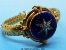 A Victorian bracelet with woven strap and a central blue guilloché enamel circular panel set with a