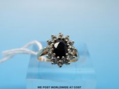 A 9ct gold ring set with an oval sapphire surrounded by cubic zirconia (size H)