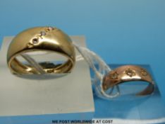 A yellow metal ring marked 14k set with diamonds in a diagonal line and a 9ct gold ring set with