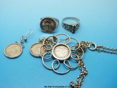 A silver pendant set with a silver coin,