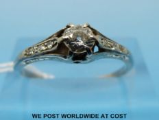 An 18ct white gold ring set with a round brilliant cut diamond with diamond encrusted shoulders