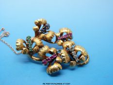 An 18ct gold brooch in the form of leaves with textured surface set with diamonds, sapphires,