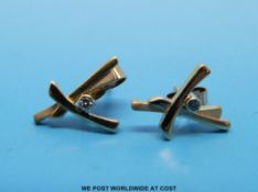 A pair of 9ct gold earrings set with a diamond to each