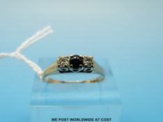 A 9ct gold ring set with a sapphire flanked by two diamonds (size O)