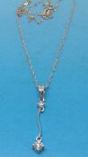 A platinum pendant set with two round brilliant cut diamonds on an 18ct white gold chain
