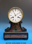 An ebonized drum head mantel clock with boulle work decoration and scrolled supports,