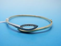 A 9ct gold bangle set with diamonds in a white gold setting