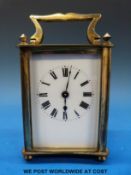 A brass timepiece carriage clock in corniche style case with finial decoration