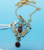 An Edwardian 9ct gold pendant set with garnets and seed pearls on a 9ct gold chain