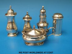 Four hallmarked  silver peppers and a silver mustard,