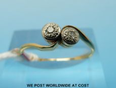 An 18ct gold ring set with two diamonds in a cross over setting (size N)