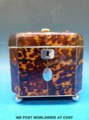 A blonde tortoiseshell and ivory two-division octagonal tea caddy raised on four ball feet (width