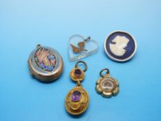 A yellow metal locket with a cross reading 'Regard' surrounded by enamelled flower with chased