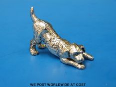 A white metal model of a playful dog (length 5cm,