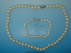 A single strand pearl necklace with a 9ct gold clasp and a bracelet