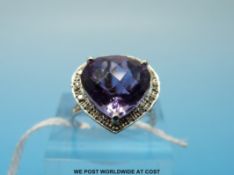 A white metal ring marked 10k set with an amethyst surrounded by diamonds (size N)