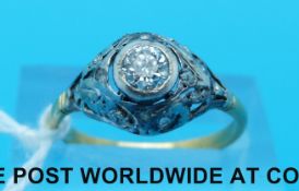 An yellow metal ring marked 18ct gold set with a round brilliant cut diamond in a platinum setting