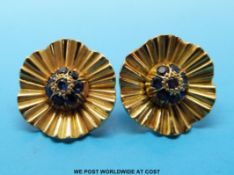 A pair of gold earrings in the form of flowers set with a cluster of sapphires to the centre,