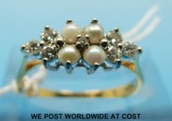 An 18ct gold ring set with four seed pearls flanked by three diamonds to each side (size L)