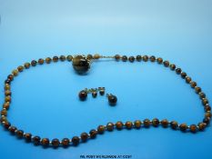 A suite of tigers eye jewellery with yellow metal fittings comprising necklace,