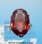 A yellow metal ring marked 9ct gold set with a large oval cut red topaz (size P)