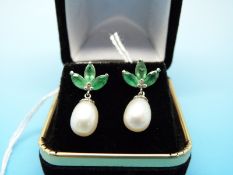 A pair of 14ct white gold earrings each set with three emeralds and a drop pearl