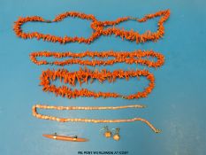 Five coral necklaces, four made up of coral strands the other of flower shapes,