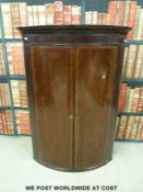 A Georgian mahogany bow-fronted hanging corner cupboard (Height 103cm)