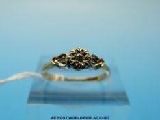 A 9ct gold ring set with three diamonds in a flower setting (size L)