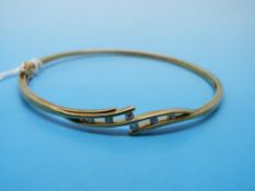 A 9ct gold bangle set with six diamonds