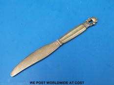 A Georg Jensen white metal letter opener with pierced acorn finial,