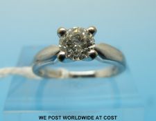 A platinum ring set with a round brilliant cut solitaire diamond of approximately 0.