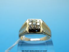 A gold ring set with nine diamonds in a square setting (size V)