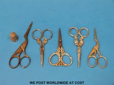 Two pairs of scissors in the form of storks, a silver handled pair of scissors of foliate design,