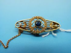 An Edwardian brooch set with seed pearls and a central sapphire