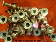 A collection of brass candlesticks and a pair of candelabra,