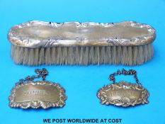 Two hallmarked silver brandy and sherry spirit labels and a silver-backed brush
