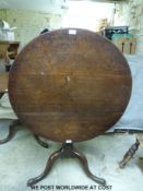 A 19thC oak tilt top table raised on a tripod base (H72 x Diameter 82cm)