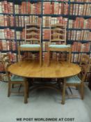 An Ercol light elm dining table with folding additional leaf and four ladder-backed chairs (Height