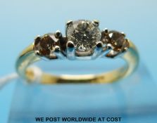 An 18ct gold ring set with a round brilliant cut diamond flanked by two brown diamonds (size M)