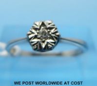 A white metal ring set with a diamond in an illusion setting (size M/N)