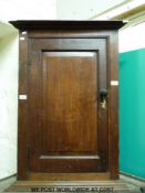 A late 19thC oak/elm wall mounted corner cupboard (H89 x W56 x D40cm)