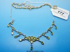 A silver necklace and bracelet set with peridot
